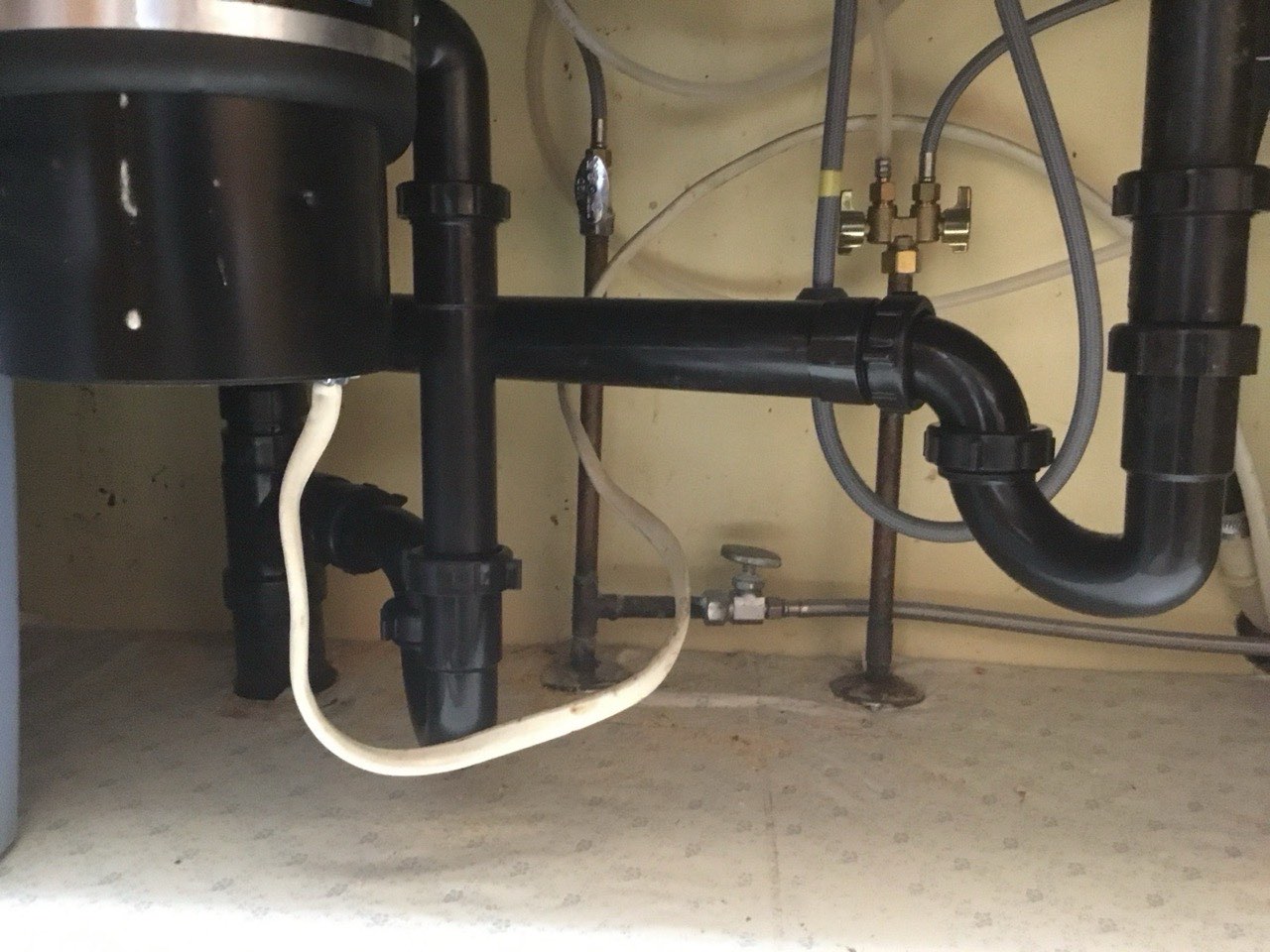 Mark Johnson & Sons Plumbing technician clearing a clogged kitchen sink drain